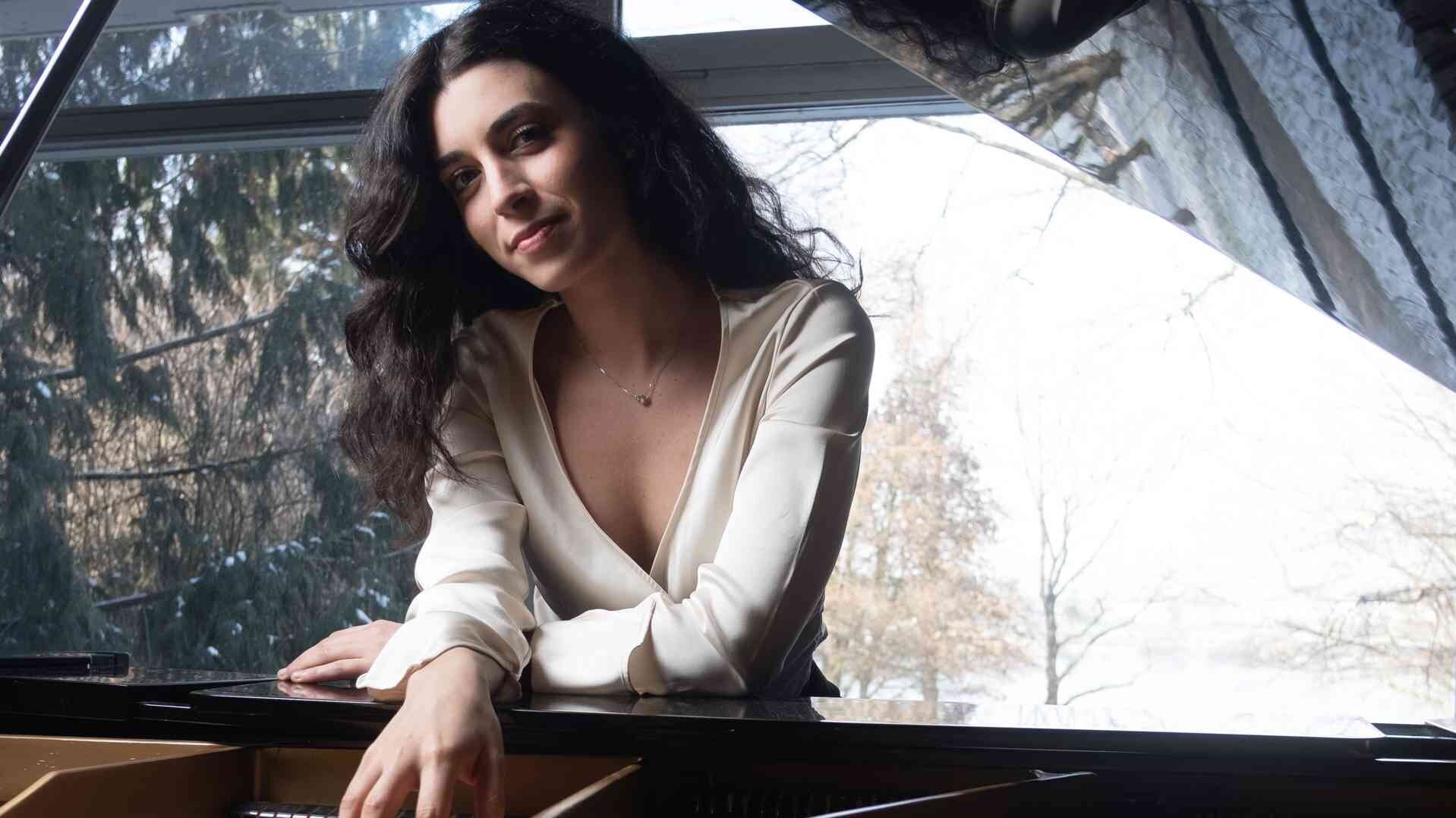 Camilla Pilla Arnese stützt sich auf einen offenen Flügel